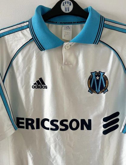 Maillot de foot vintage domicile blanc de l'OM saison 1998/1999. On peut retrouver l'équipementier Adidas et le sponsor Ericsson. Il s'agit d'un maillot authentique d'époque.
