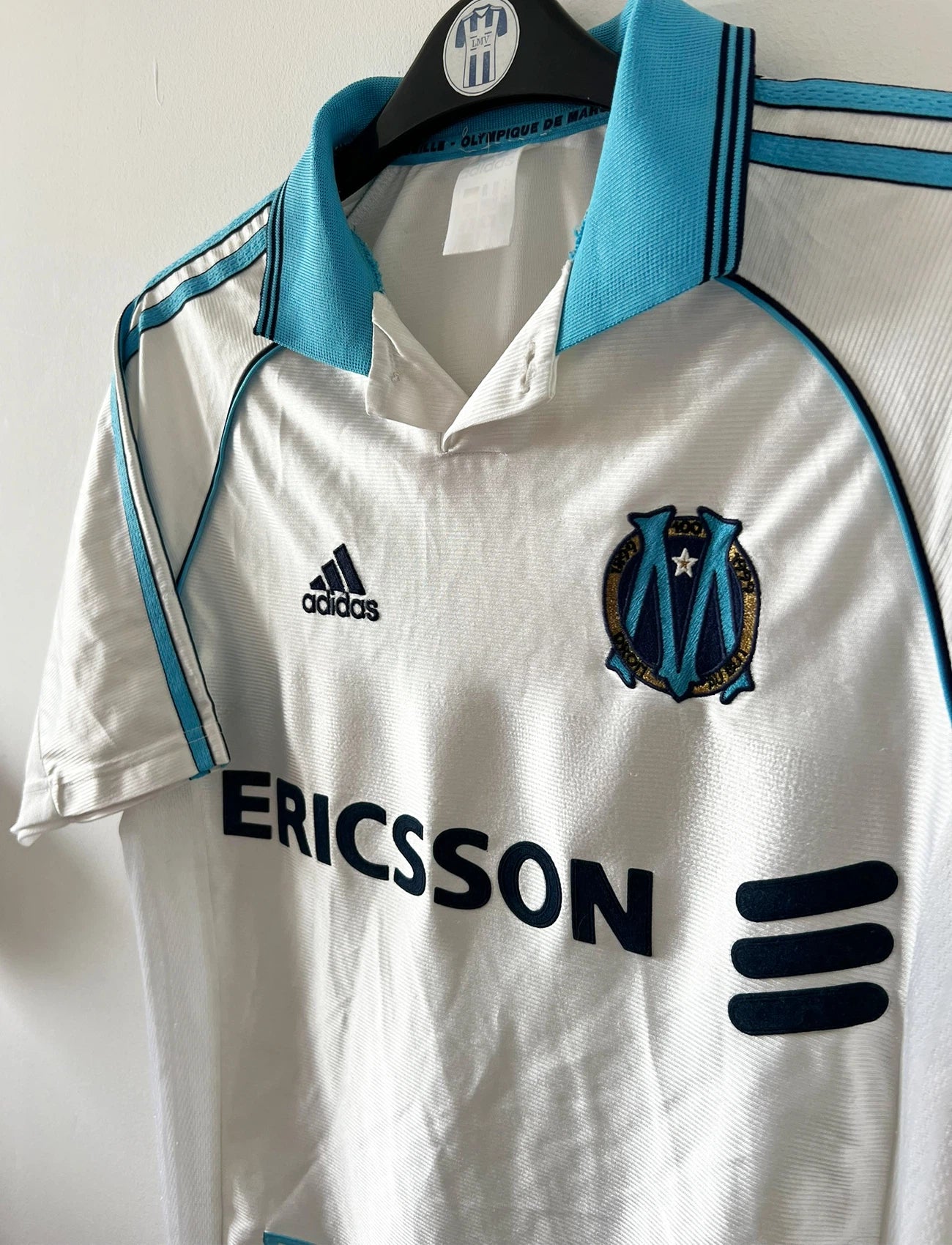 Maillot de foot vintage domicile blanc de l'OM 1998/1999. On peut retrouver l'équipementier Adidas et le sponsor Ericsson. Il s'agit d'un maillot authentique d'époque.