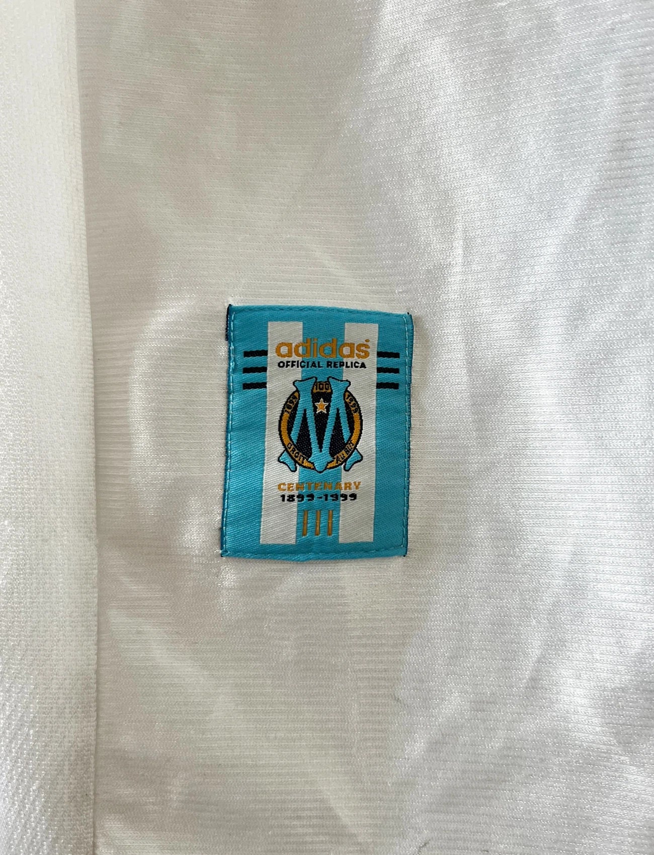 Maillot de foot vintage domicile blanc de l'OM 1998/1999. On peut retrouver l'équipementier Adidas et le sponsor Ericsson. Il s'agit d'un maillot authentique d'époque.