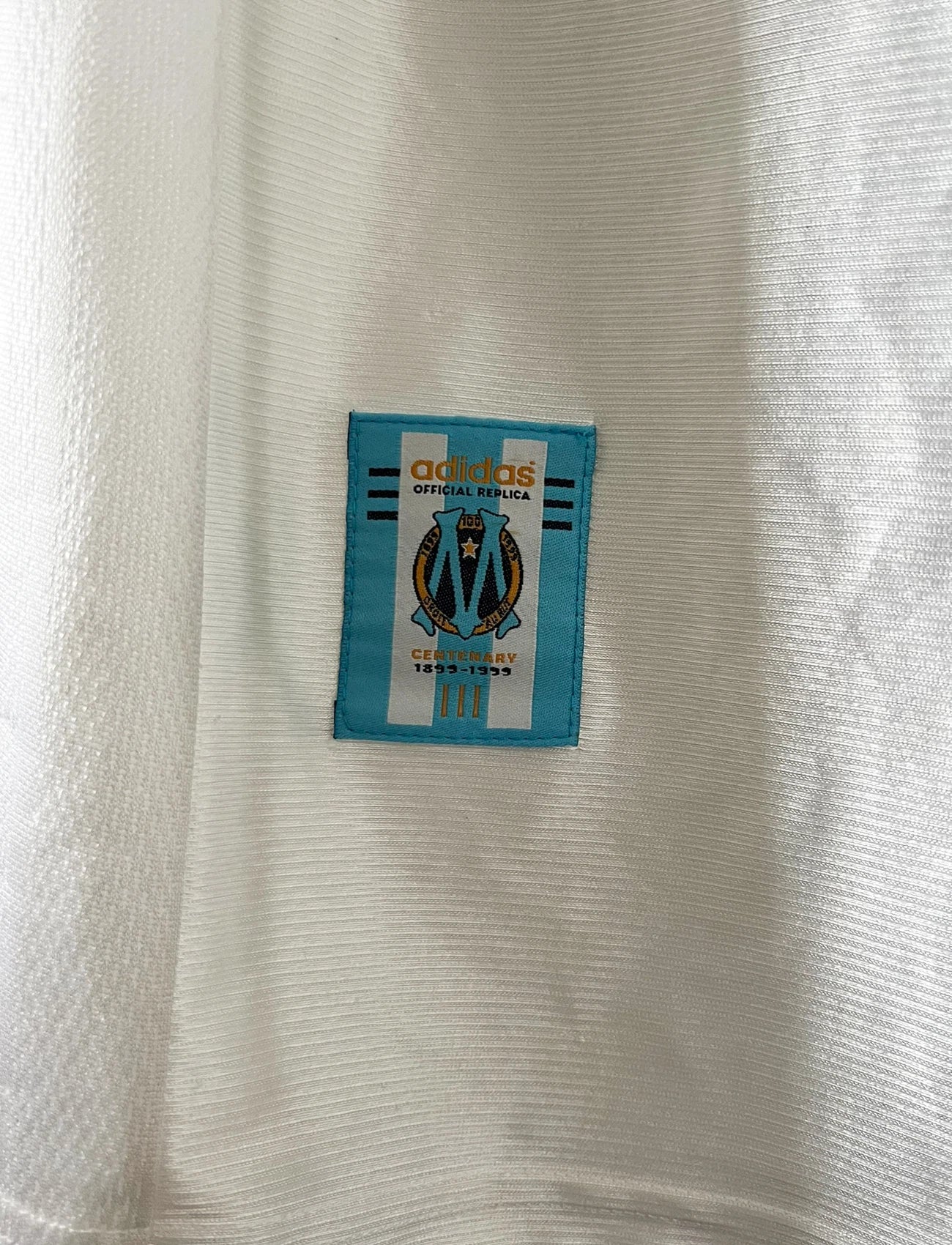 Maillot de foot vintage domicile OM 1998/1999. On peut retrouver l'équipementier Adidas et le sponsor Ericsson. Il s'agit d'un maillot authentique d'époque.