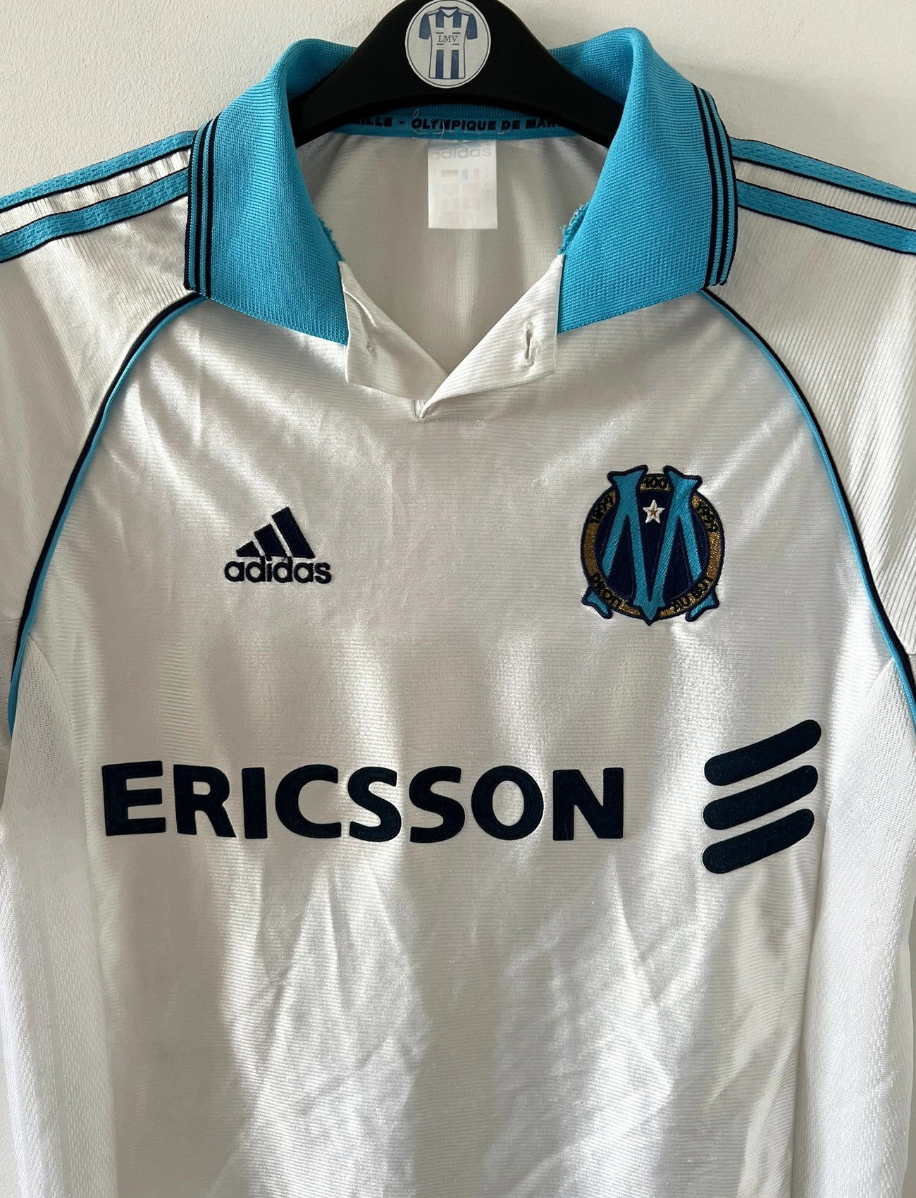 Maillot de foot vintage domicile blanc de l'OM 1998/1999. On peut retrouver l'équipementier Adidas et le sponsor Ericsson. Il s'agit d'un maillot authentique d'époque.