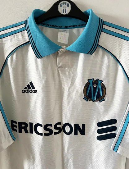 Maillot de foot vintage domicile OM 1998/1999. On peut retrouver l'équipementier Adidas et le sponsor Ericsson. Il s'agit d'un maillot authentique d'époque.