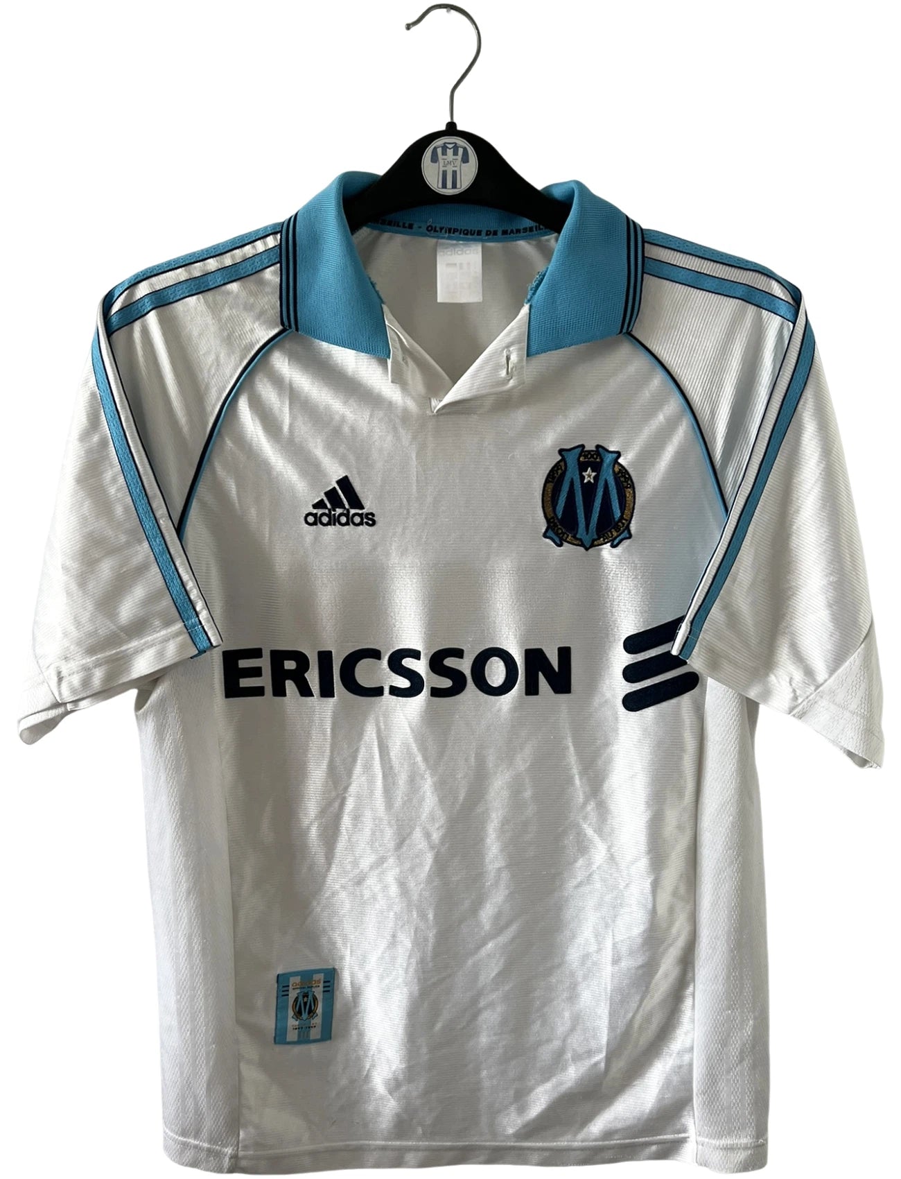 Maillot de foot vintage domicile blanc de l'OM 1998/1999. On peut retrouver l'équipementier Adidas et le sponsor Ericsson. Il s'agit d'un maillot authentique d'époque.