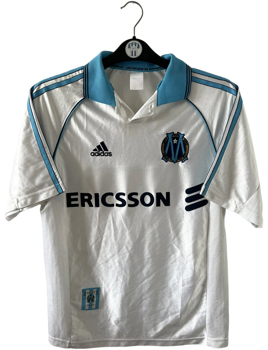 Maillot de foot vintage domicile blanc de l'OM 1998/1999. On peut retrouver l'équipementier Adidas et le sponsor Ericsson. Il s'agit d'un maillot authentique d'époque.