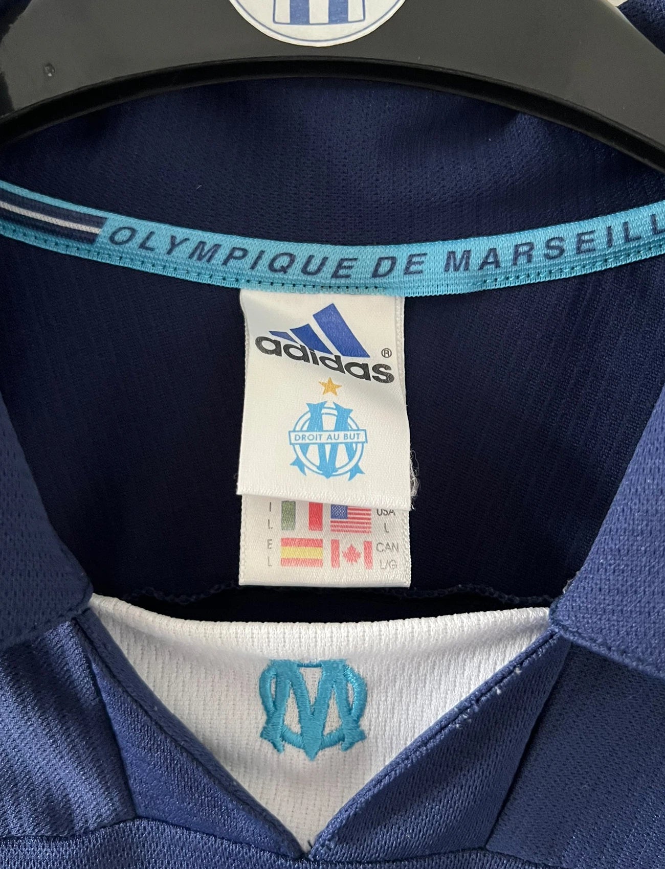 Maillot de foot vintage OM 1999/2000 extérieur bleu. On peut retrouver l'équipementier Adidas et le sponsor Ericsson. Il s'agit d'un maillot authentique d'époque.
