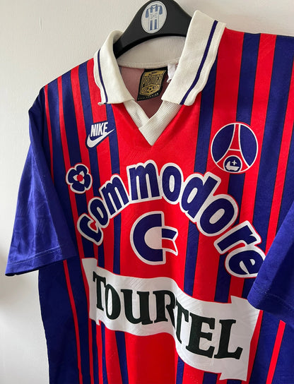 Maillot de foot vintage domicile rouge et bleu du PSG 1993/1994. On peut retrouver l'équipementier Nike et le sponsor Commodore et Tourtel. Il s'agit d'un maillot authentique d'époque.