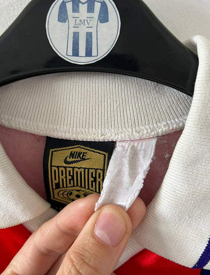 Maillot de foot vintage domicile rouge et bleu du PSG 1993/1994. On peut retrouver l'équipementier Nike et le sponsor Commodore et Tourtel. Il s'agit d'un maillot authentique d'époque.