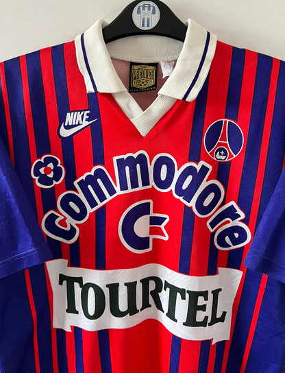 Maillot de foot vintage domicile rouge et bleu du PSG 1993/1994. On peut retrouver l'équipementier Nike et le sponsor Commodore et Tourtel. Il s'agit d'un maillot authentique d'époque.