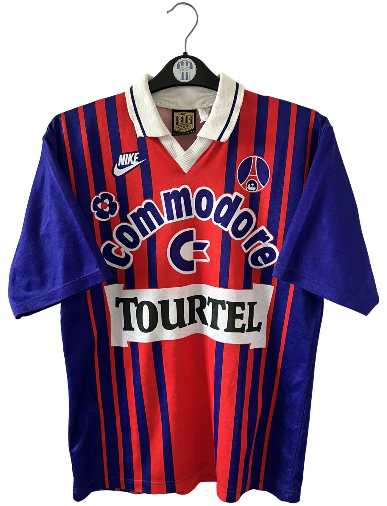 Maillot de foot vintage domicile rouge et bleu du PSG 1993/1994. On peut retrouver l'équipementier Nike et le sponsor Commodore et Tourtel. Il s'agit d'un maillot authentique d'époque.