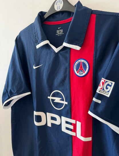 Maillot de foot vintage domicile bleu et rouge du PSG 2001/2002. On peut retrouver l'équipementier Nike et le sponsor OPEL. Il s'agit d'un maillot authentique d'époque.