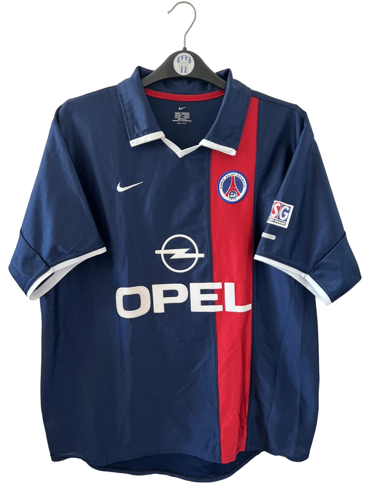 Maillot de foot vintage domicile bleu et rouge du PSG 2001/2002. On peut retrouver l'équipementier Nike et le sponsor OPEL. Il s'agit d'un maillot authentique d'époque.