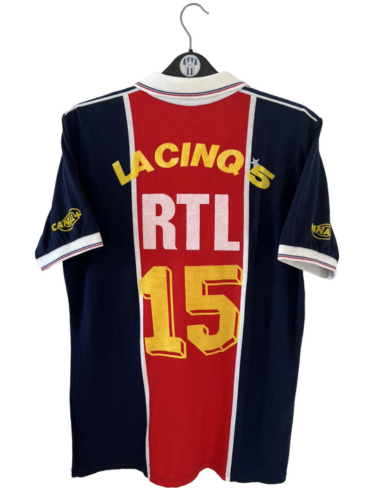 Maillot de foot vintage domicile bleu et rouge du PSG de la saison 1987/1988. On peut retrouver l'équipementier Adidas et le sponsor RTL, Canal + et La Cinq. Il s'agit d'un maillot authentique d'époque.