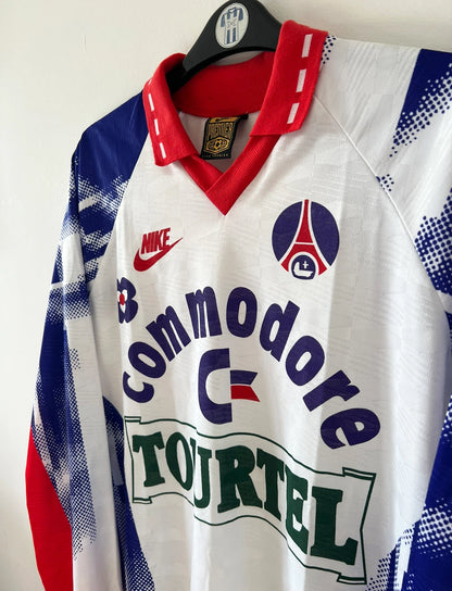 Maillot de foot vintage domicile blanc du PSG de la saison 1992/1993. On peut retrouver l'équipementier Nike et les sponsors Commoore et Tourtel. Il s'agit d'un maillot authentique d'époque.