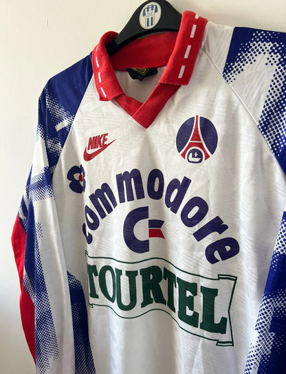 Maillot de foot vintage domicile blanc du PSG de la saison 1992/1993. On peut retrouver l'équipementier Nike et le sponsor Tourtel et Commodore. Il s'agit d'un maillot authentique d'époque.