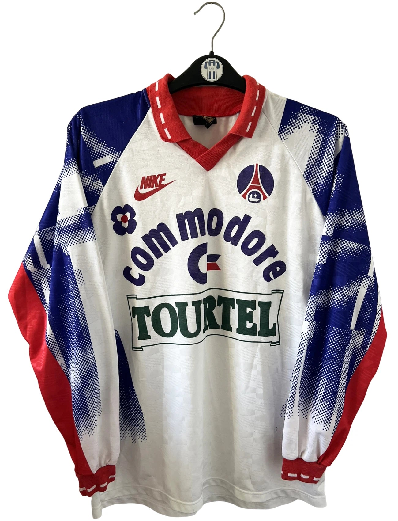 Maillot de foot vintage domicile blanc du PSG de la saison 1992/1993. On peut retrouver l'équipementier Nike et le sponsor Tourtel et Commodore. Il s'agit d'un maillot authentique d'époque.