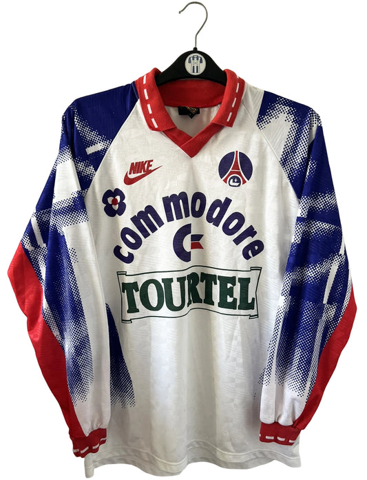 Maillot de foot vintage domicile blanc du PSG de la saison 1992/1993. On peut retrouver l'équipementier Nike et le sponsor Tourtel et Commodore. Il s'agit d'un maillot authentique d'époque.