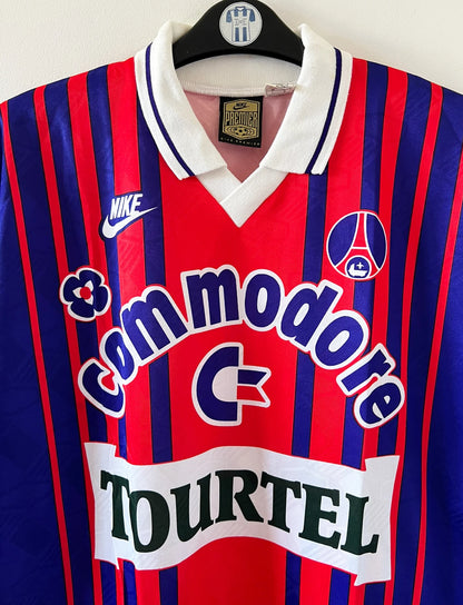 Maillot de foot vintage domicile rouge et bleu du PSG 1993/1994. On peut retrouver l'équipementier Nike et les sponsors Tourtel et commodore. Il s'agit d'un maillot authentique d'époque.