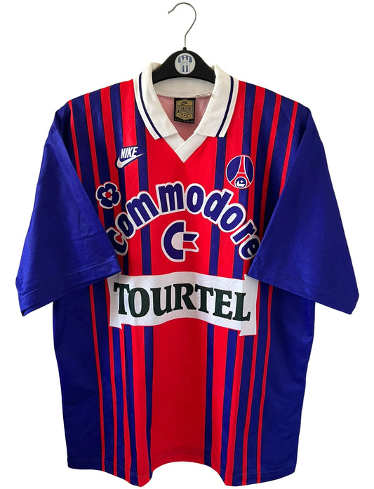 Maillot de foot vintage domicile rouge et bleu du PSG 1993/1994. On peut retrouver l'équipementier Nike et les sponsors Tourtel et commodore. Il s'agit d'un maillot authentique d'époque.