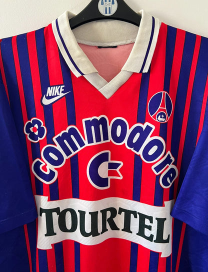 Maillot vintage domicile rouge et bleu du PSG de la saison 1993/1994. On peut retrouver l'équipementier nike, le sponsor commodore et le sponsor tourtel. Il s'agit d'un maillot authentique d'époque.
