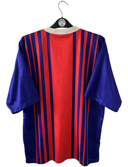 Maillot de foot vintage domicile rouge et bleu du PSG 1993/1994. On peut retrouver l'équipementier Nike et le sponsor Tourtel. Il s'agit d'un maillot authentique d'époque.