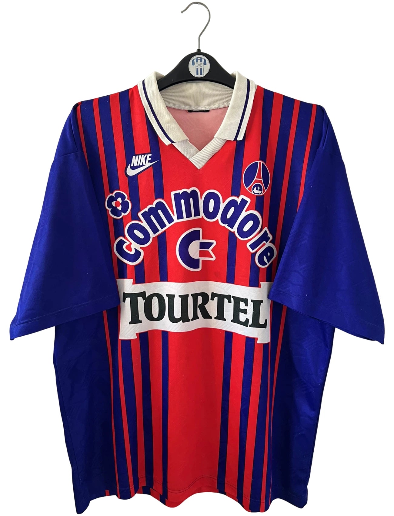 Maillot vintage domicile rouge et bleu du PSG de la saison 1993/1994. On peut retrouver l'équipementier nike, le sponsor commodore et le sponsor tourtel. Il s'agit d'un maillot authentique d'époque.