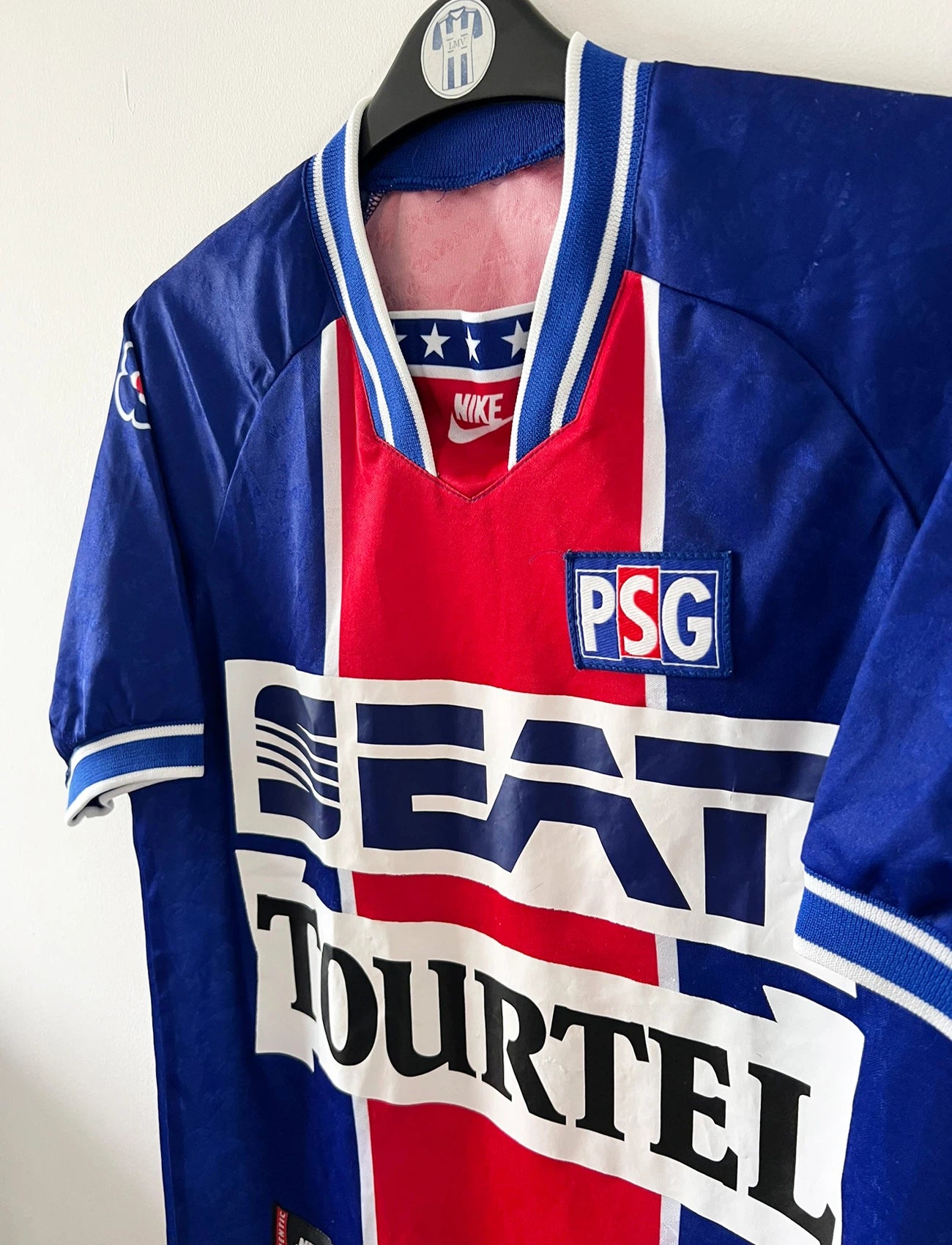 Maillot de foot vintage domicile bleu et rouge du PSG 1994/1995. On peut retrouver l'équipementier Nike et les sponsor SEAT, Tourtel et Liptonic. Il s'agit d'un maillot authentique d'époque.