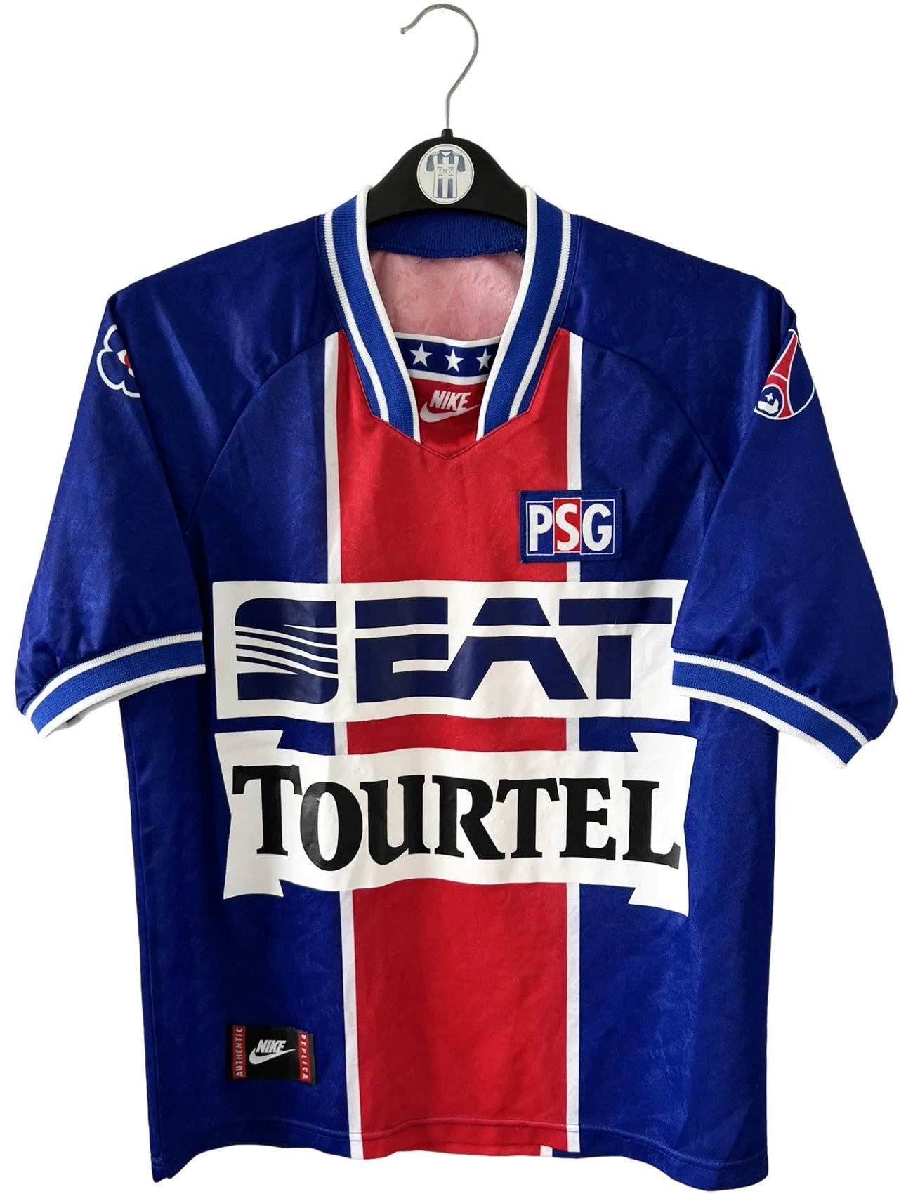 Maillot de foot vintage domicile bleu et rouge du PSG 1994/1995. On peut retrouver l'équipementier Nike et les sponsor SEAT, Tourtel et Liptonic. Il s'agit d'un maillot authentique d'époque.