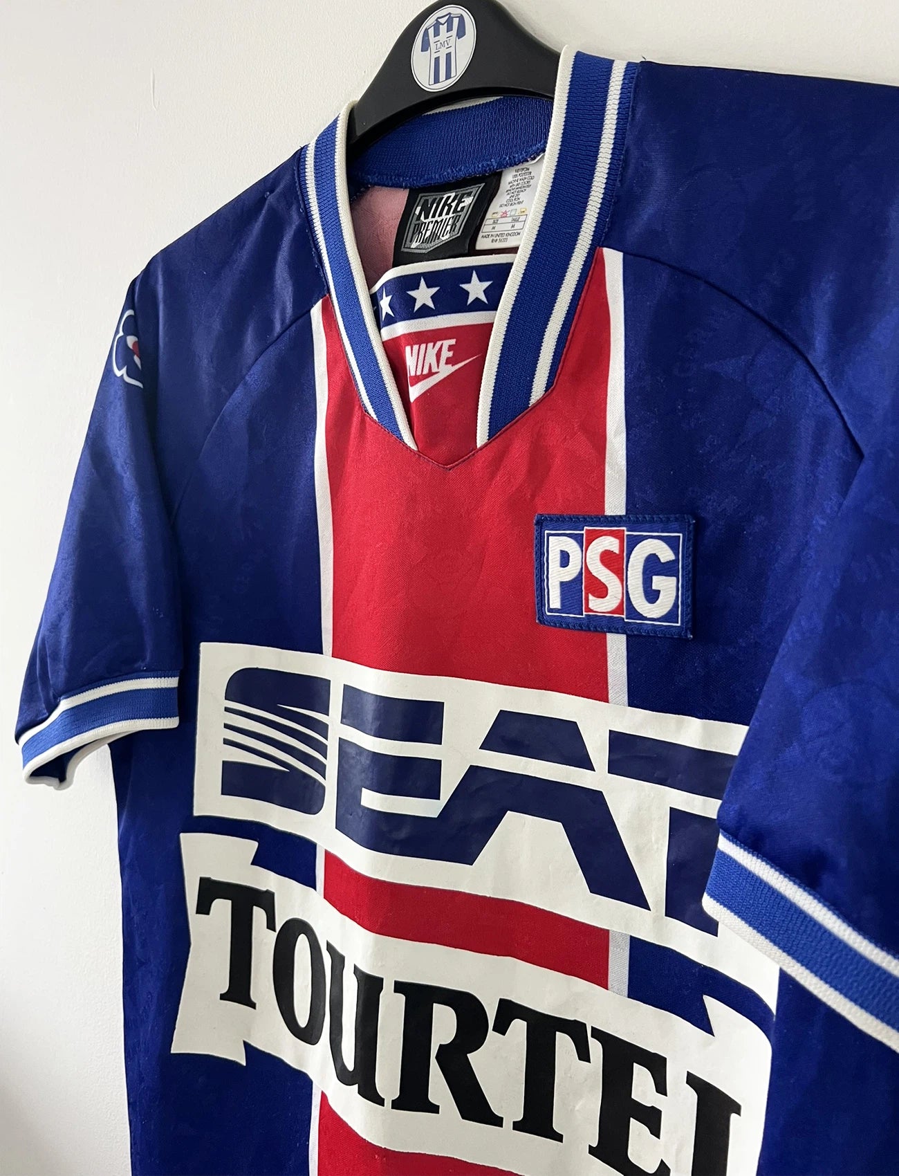 Maillot de foot vintage domicile bleu et rouge du PSG de la saison 1994/1995. On peut retrouver l'équipementier Nike et les sponsors Seat, Tourtel et Liptonic. Il s'agit d'un maillot authentique d'époque.
