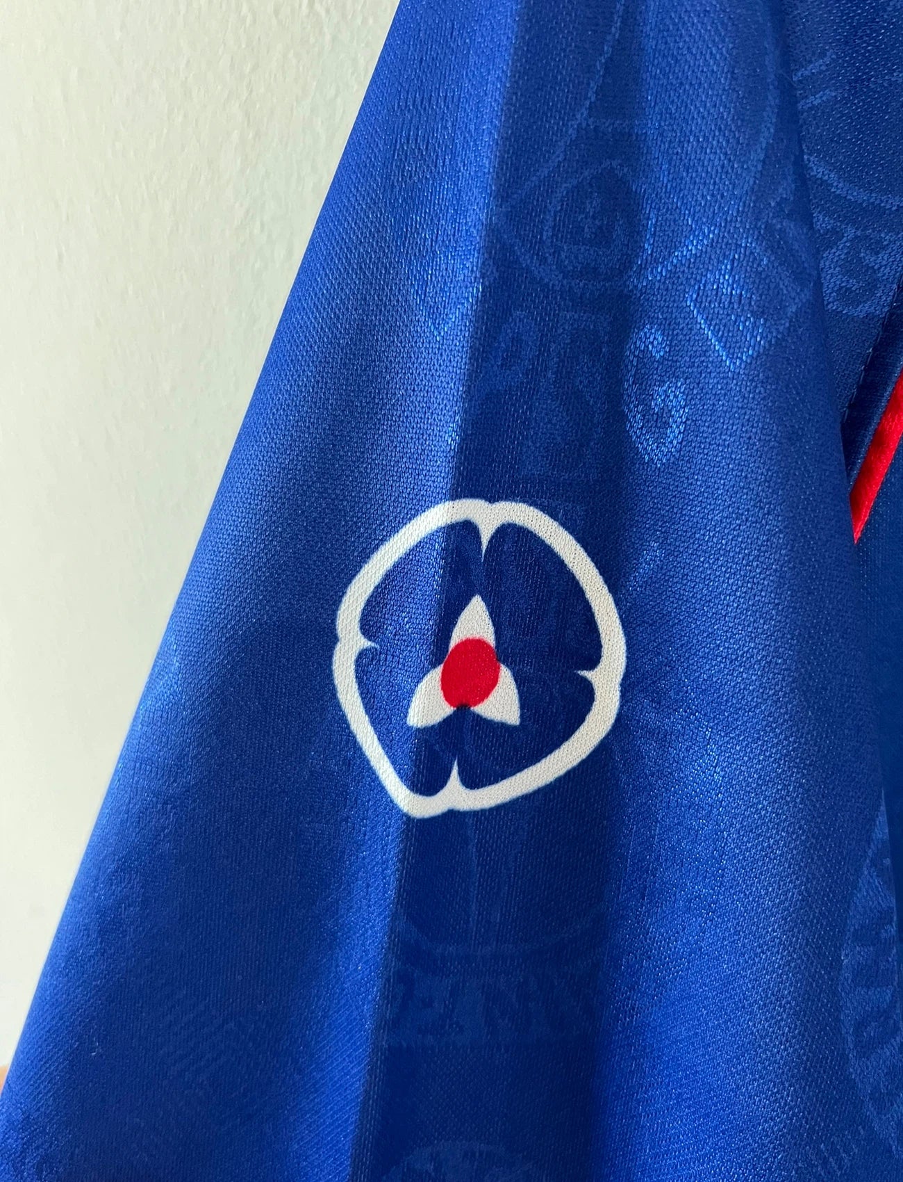 Maillot de foot vintage domicile rouge et bleu du PSG de la saison 1996/1997. On peut retrouver la fameuse bande hechter avec l'équipementier Nike et le sponsor Opel. Il s'agit d'un maillot authentique d'époque.