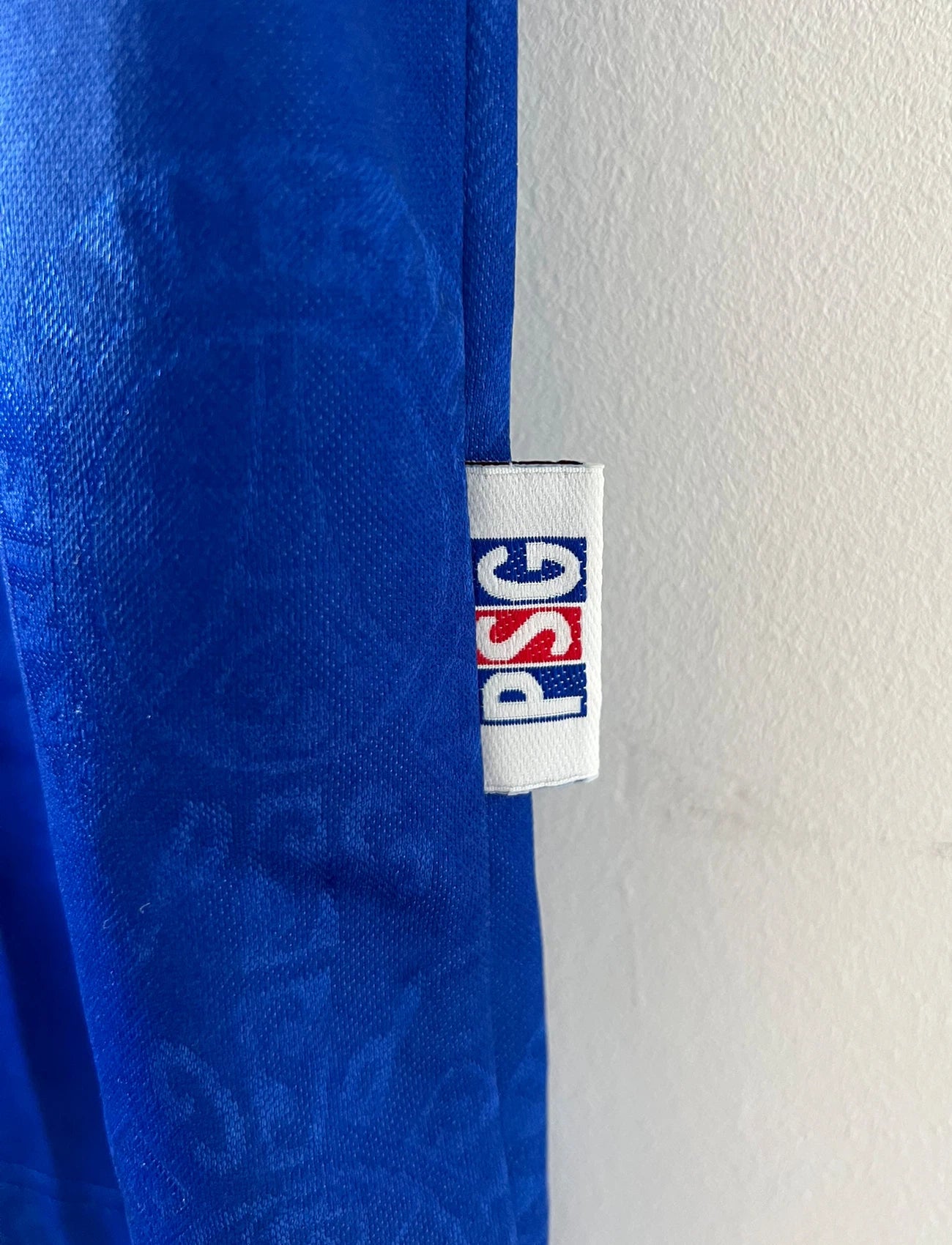 Maillot de foot vintage domicile rouge et bleu du PSG de la saison 1996/1997. On peut retrouver la fameuse bande hechter avec l'équipementier Nike et le sponsor Opel. Il s'agit d'un maillot authentique d'époque.