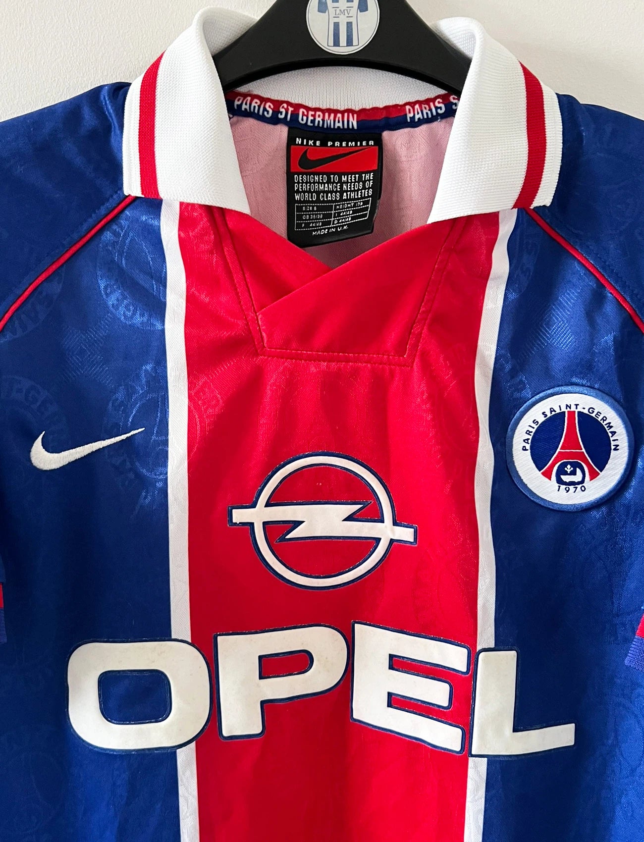 Maillot de foot vintage domicile bleu et rouge du PSG 1996/1997. On peut retrouver l'équipementier Nike et le sponsor OPEL. Il s'agit d'un maillot authentique d'époque.