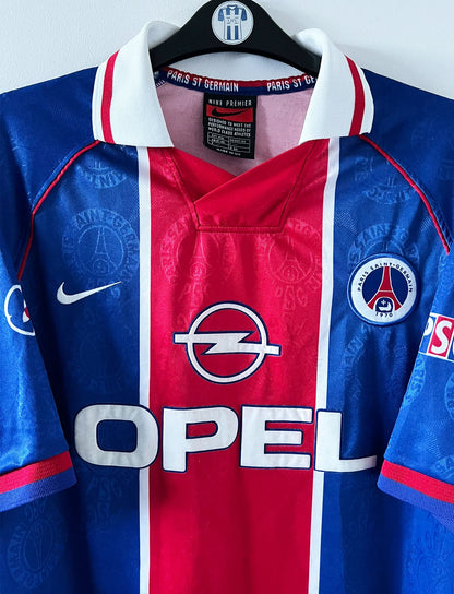 Maillot de foot vintage domicile psg 1996/1997. On peut retrouver l'équipementier Nike et le sponsor Opel. Il s'agit d'un maillot authentique d'époque.
