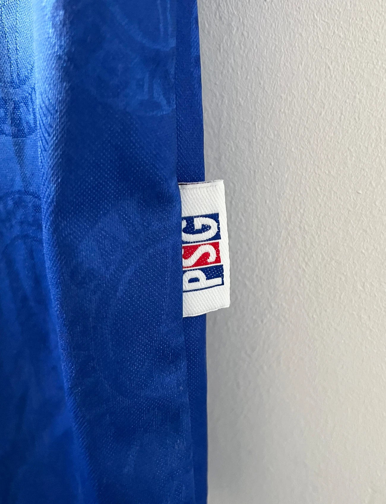 Maillot de foot vintage domicile bleu et rouge du PSG 1996/1997. On peut retrouver l'équipementier Nike et le sponsor OPEL. Il s'agit d'un maillot authentique d'époque.