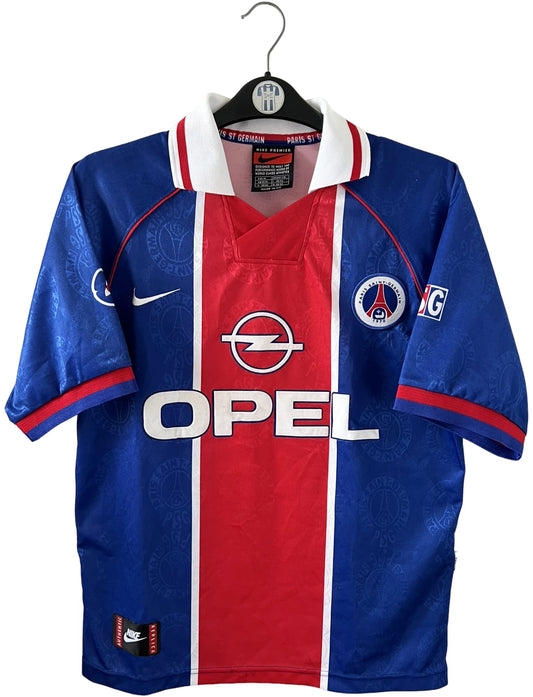 Maillot de foot vintage domicile bleu et rouge du PSG 1996/1997. On peut retrouver l'équipementier Nike et le sponsor OPEL. Il s'agit d'un maillot authentique d'époque.