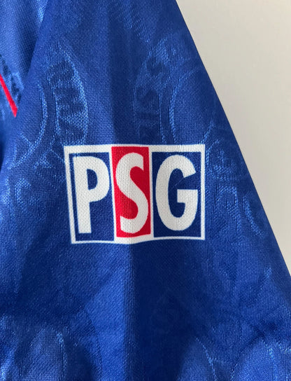 Maillot de foot vintage domicile bleu et rouge du PSG 1996/1997. On peut retrouver l'équipementier Nike et le sponsor OPEL. Il s'agit d'un maillot authentique d'époque.