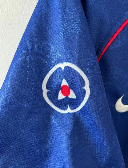 Maillot de foot vintage domicile bleu et rouge du PSG 1996/1997. On peut retrouver l'équipementier Nike et le sponsor OPEL. Il s'agit d'un maillot authentique d'époque.