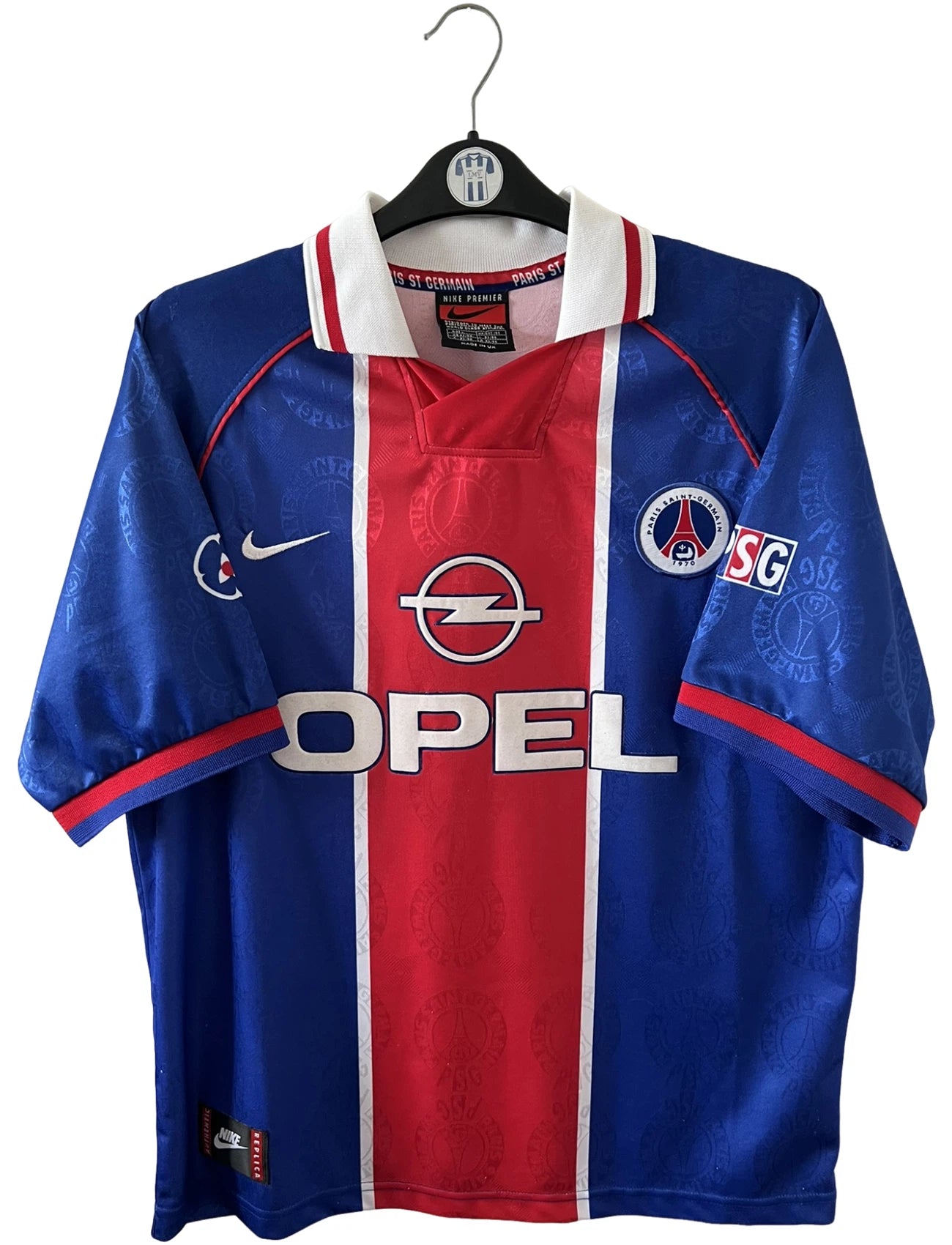 Maillot de foot vintage domicile bleu et rouge du PSG 1996. On peut retrouver l'équipementier Nike et le sponsor Opel. Il s'agit d'un maillot authentique d'époque.