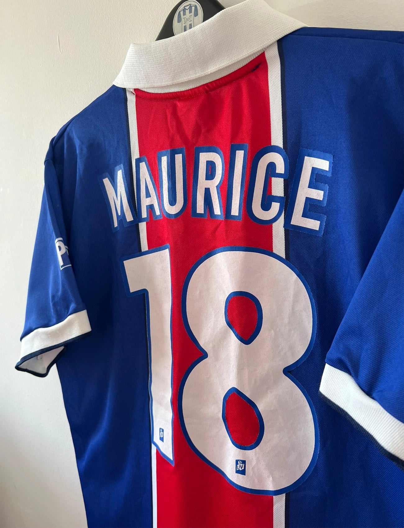 Maillot de foot vintage domicile PSG 1997/1998. On peut retrouver l'équipementier Nike et le sponsor Opel. Le maillot est floqué du numéro 18 Florian Maurice. Il s'agit d'un maillot authentique d'époque.