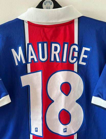 Maillot de foot vintage domicile PSG 1997/1998. On peut retrouver l'équipementier Nike et le sponsor Opel. Le maillot est floqué du numéro 18 Florian Maurice. Il s'agit d'un maillot authentique d'époque.