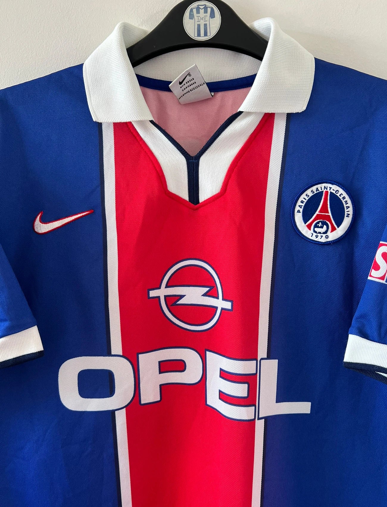 Maillot de foot vintage domicile PSG 1997/1998. On peut retrouver l'équipementier Nike et le sponsor Opel. Le maillot est floqué du numéro 18 Florian Maurice. Il s'agit d'un maillot authentique d'époque.