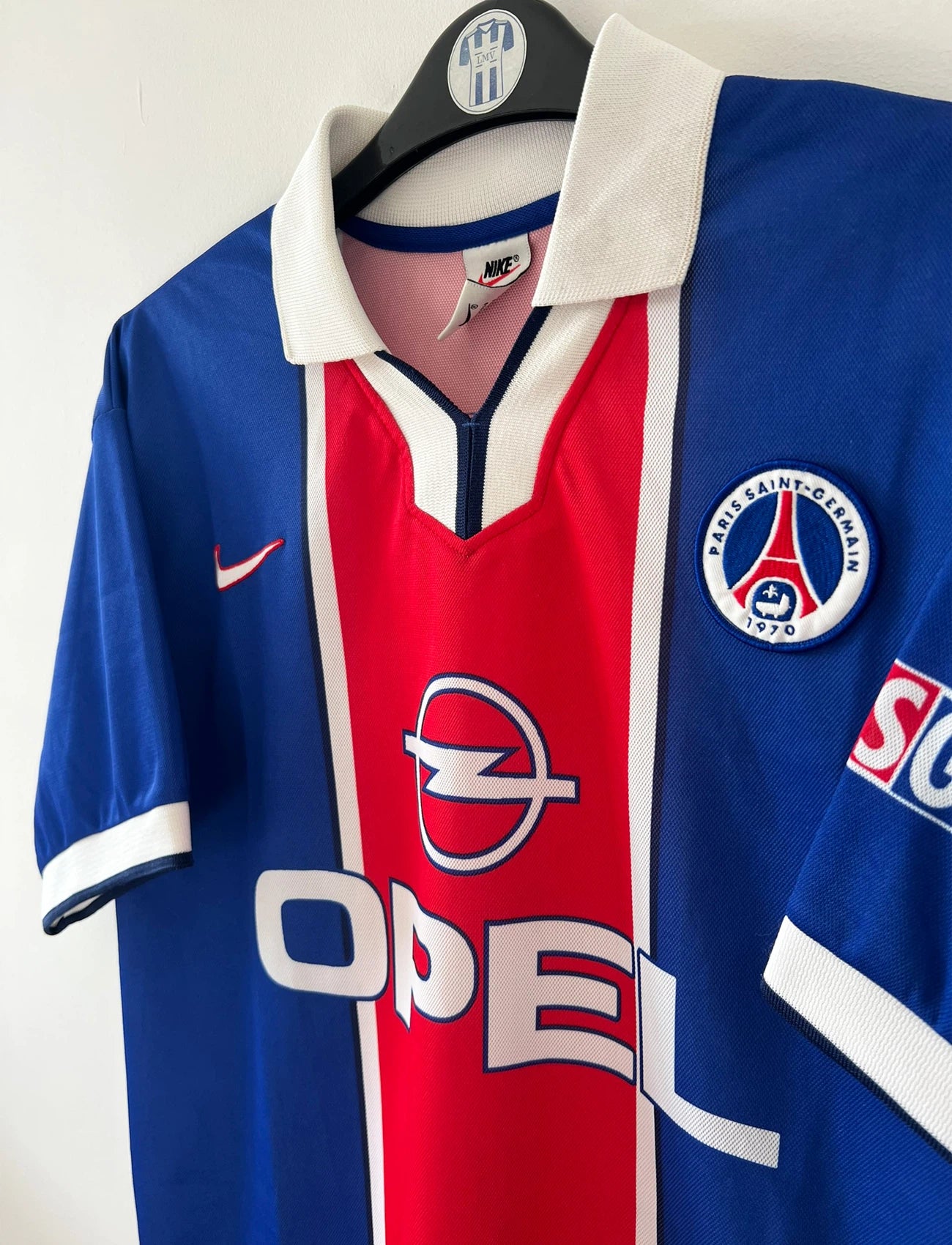 Maillot de foot vintage domicile bleu et rouge du PSG de la saison 1997/1998. On peut retrouver l'équipementier Nike et le sponsor Opel. Il s'agit d'un maillot authentique d'époque.