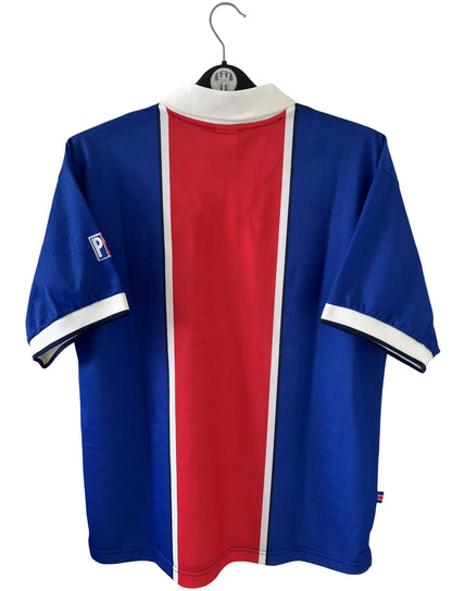 Maillot de foot vintage domicile bleu et rouge du PSG de la saison 1997/1998. On peut retrouver l'équipementier Nike et le sponsor Opel. Il s'agit d'un maillot authentique d'époque.