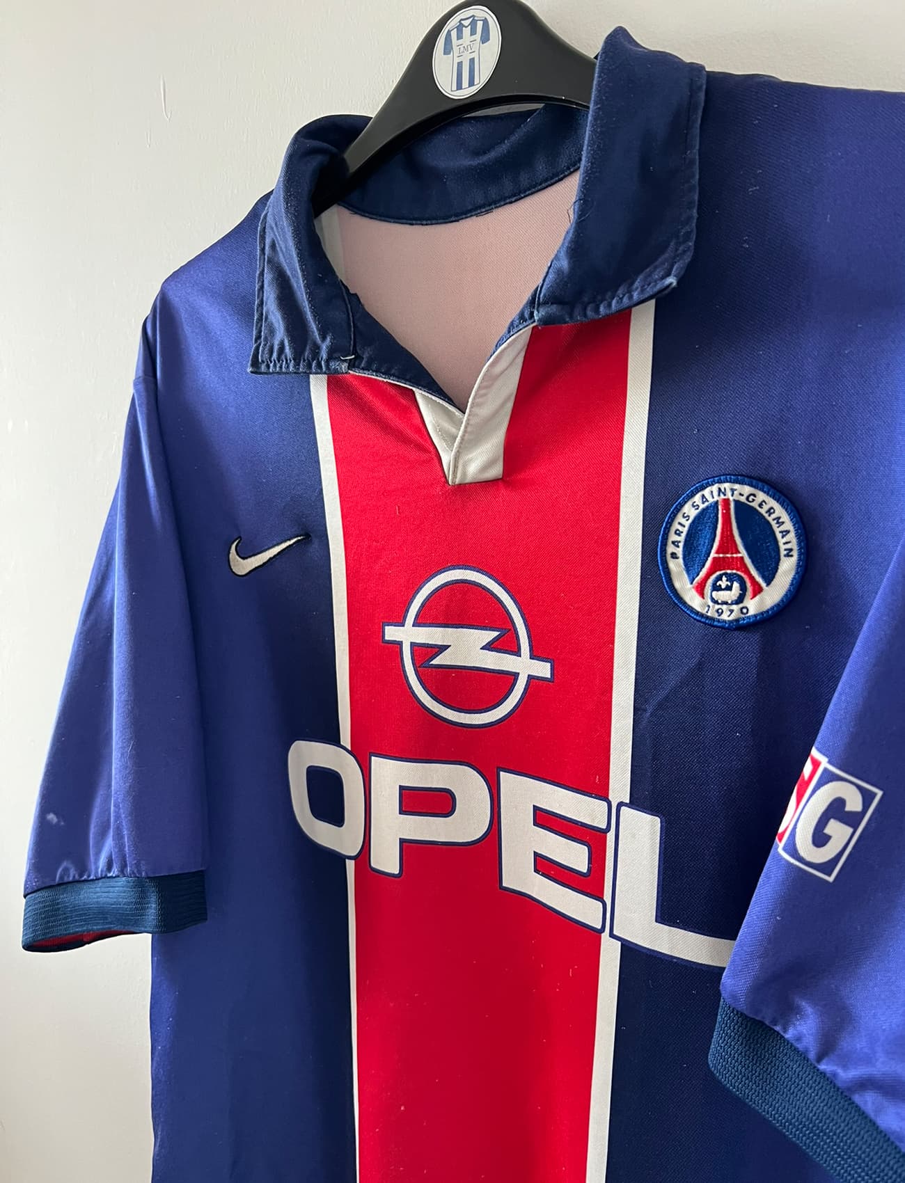 Maillot de foot vintage domicile bleu et rouge du PSG 1998/1999. On peut retrouver l'équipementier Nike et le sponsor Opel. Il s'agit d'un maillot authentique d'époque.