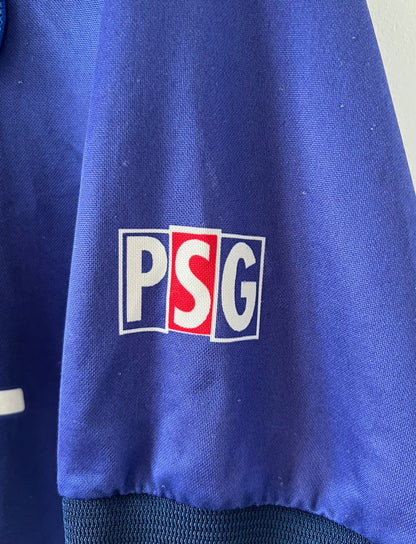 Maillot de foot vintage domicile bleu et rouge du PSG 1998/1999. On peut retrouver l'équipementier Nike et le sponsor Opel. Il s'agit d'un maillot authentique d'époque.