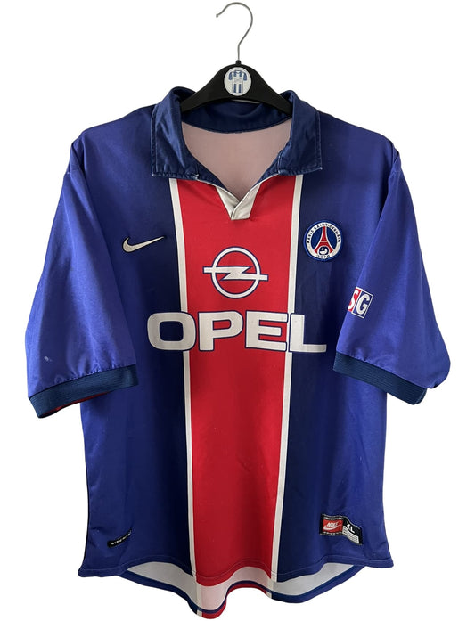 Maillot de foot vintage domicile bleu et rouge du PSG 1998/1999. On peut retrouver l'équipementier Nike et le sponsor Opel. Il s'agit d'un maillot authentique d'époque.