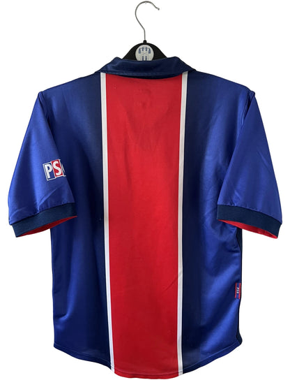 Maillot de foot vintage domicile bleu et rouge du PSG 1998/1999. On peut retrouver l'équipementier Nike et le sponsor Opel. Il s'agit d'un maillot authentique d'époque.