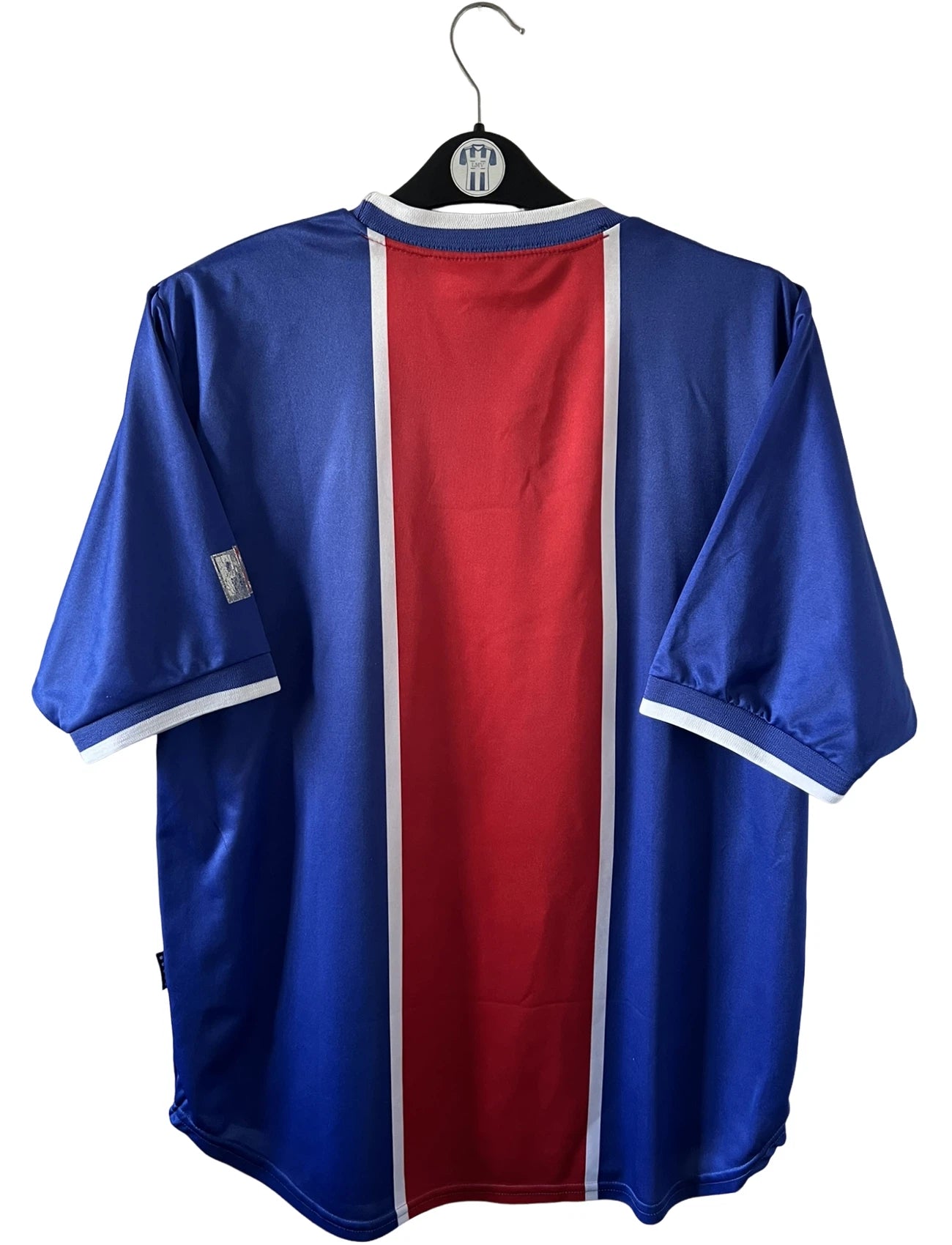 Maillot de foot vintage domicile rouge et bleu du PSG 1999/2000. On peut retrouver l'équipementier Nike et le sponsor OPEL. Il s'agit d'un maillot authentique d'époque.