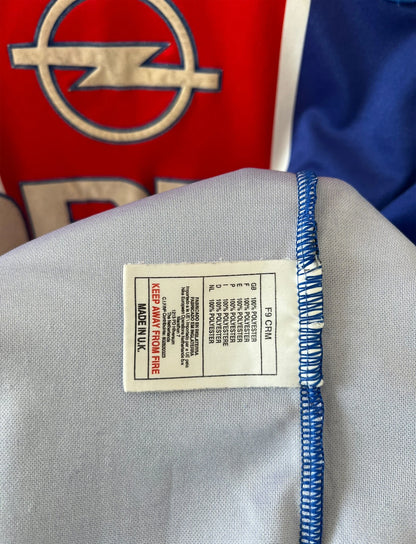 Maillot de foot vintage domicile bleu et rouge du PSG 1999/2000. On peut retrouver l'équipementier Nike et le sponsor Opel. Il s'agit d'un maillot authentique d'époque.