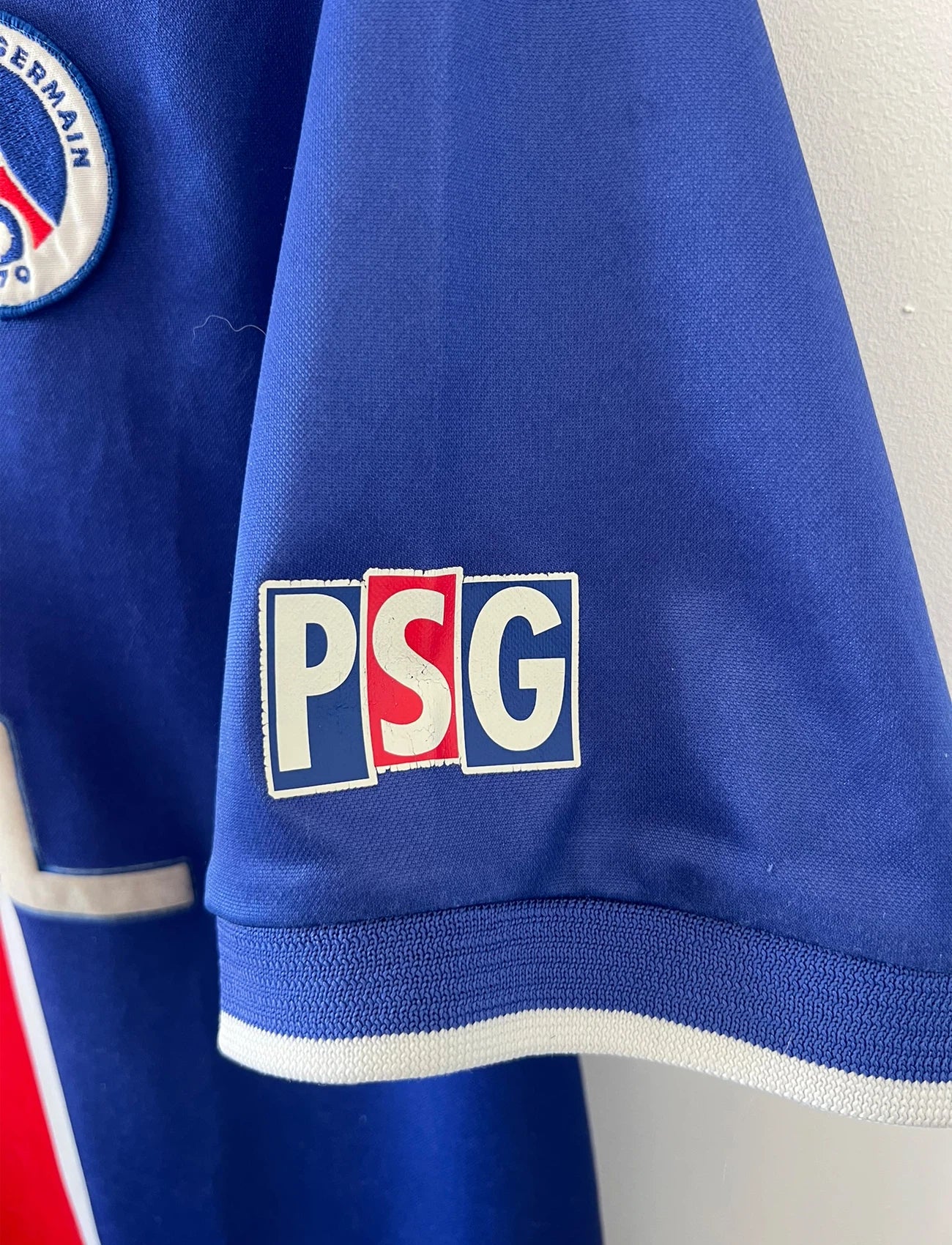 Maillot de foot vintage domicile bleu et rouge du PSG 1999/2000. On peut retrouver l'équipementier Nike et le sponsor Opel. Il s'agit d'un maillot authentique d'époque.