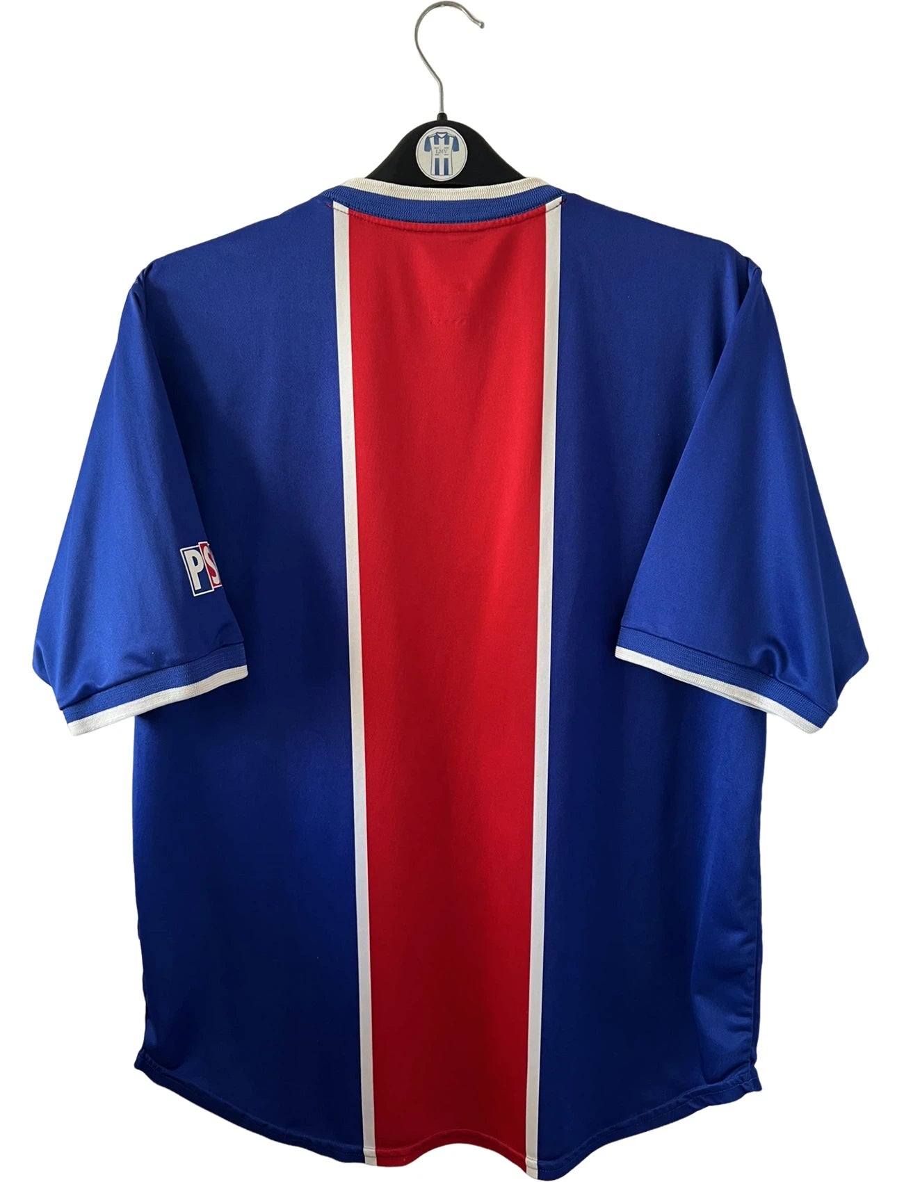 Maillot de foot vintage domicile bleu et rouge du PSG 1999/2000. On peut retrouver l'équipementier Nike et le sponsor Opel. Il s'agit d'un maillot authentique d'époque.